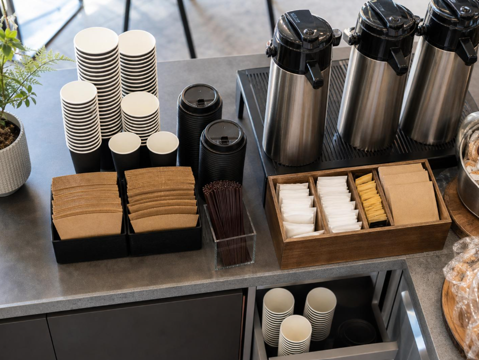 展示会でスタッフが業務用コーヒーメーカーを使い、来場者に紙カップでコーヒーを提供する様子
